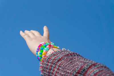Close-up of multi colored hand against clear blue sky