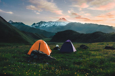 Tent on field by mountains against sky