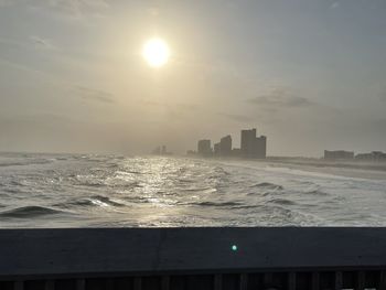 Scenic view of sea and buildings against sky during sunset