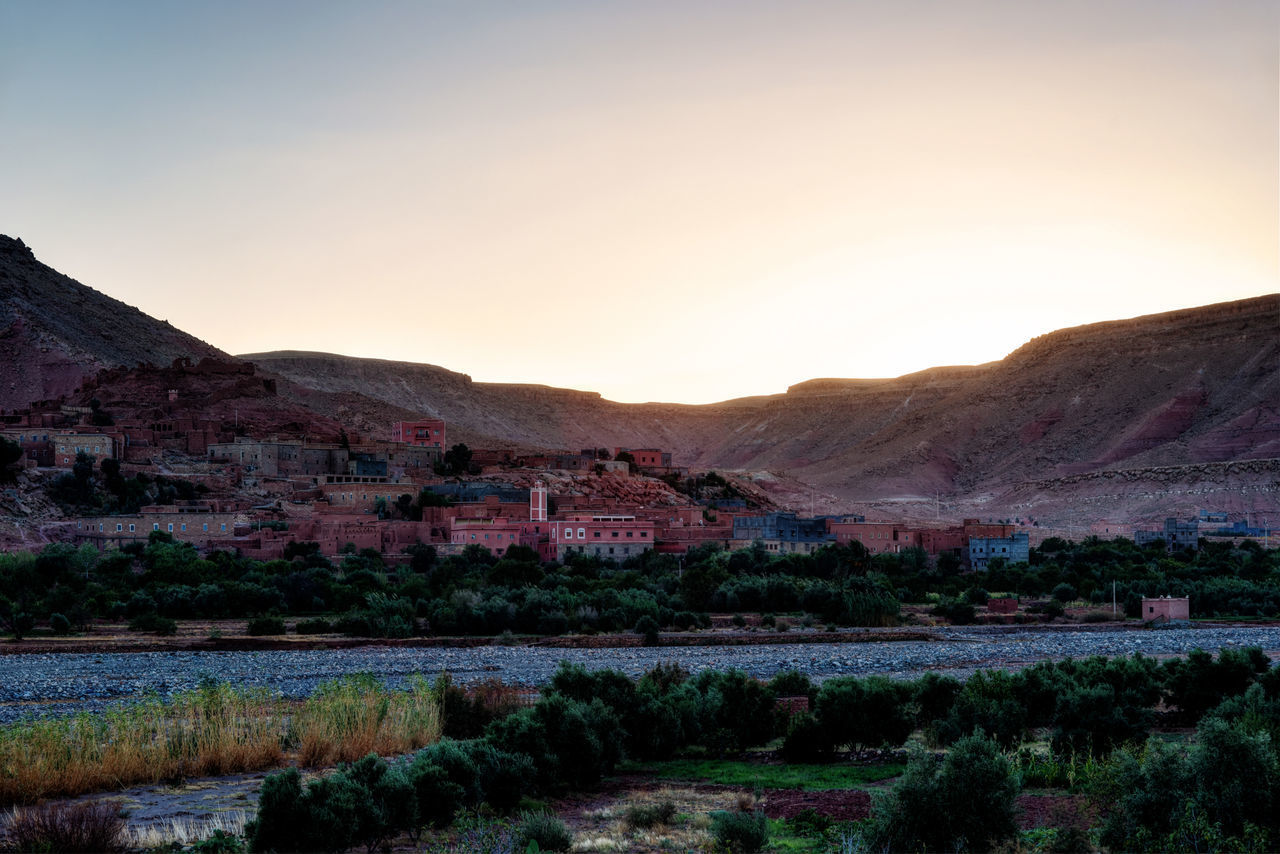 SCENIC VIEW OF HOUSES AND MOUNTAINS AGAINST SKY