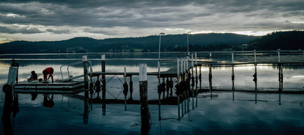 People on lake against sky