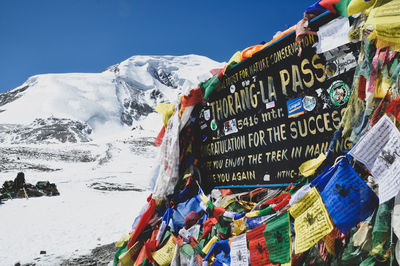 Graffiti on wall of snowcapped mountain against sky