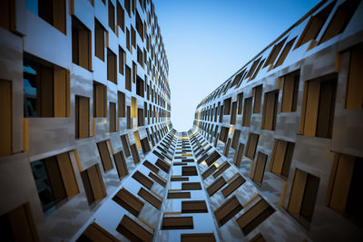 Directly below shot of modern buildings against clear sky