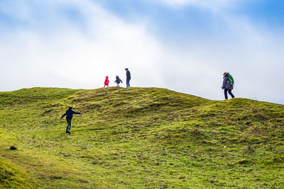 People standing on mountain road against sky