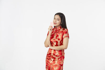 Young woman standing against white background