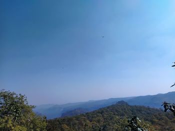 Scenic view of mountains against blue sky