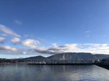 Scenic view of sea by mountains against sky