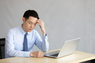 Young man using mobile phone while sitting on table