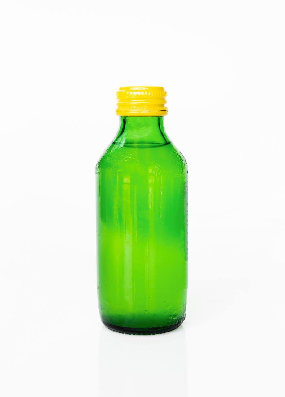 CLOSE-UP OF GREEN BOTTLE ON GLASS