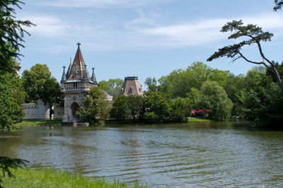 Scenic view of river by temple against sky