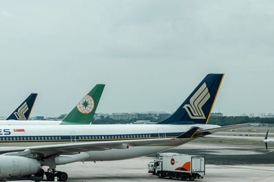 Airplane on airport runway against sky