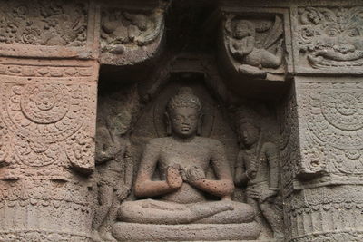 Stone carved sculptures on the facade of ajanta cave. sitting buddha.	
