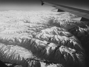 Aerial view of landscape and airplane wing