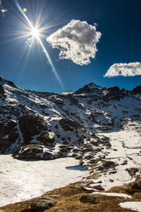 Scenic view of snowcapped mountains against sky on sunny day