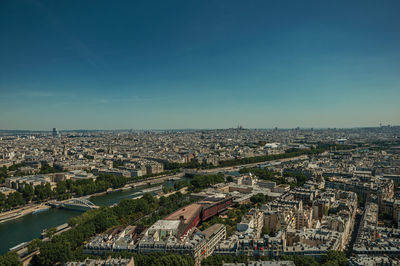 High angle view of buildings in city against blue sky