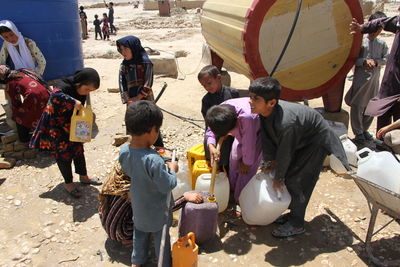 Displaced afghan children collecting water