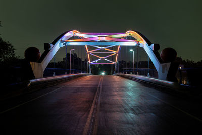 Illuminated bridge against sky at night