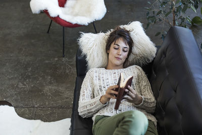 Portrait of smiling woman sitting on sofa