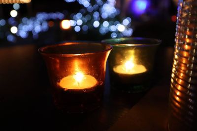 Close-up of illuminated tea light candles on table