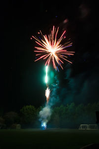 Low angle view of firework display at night