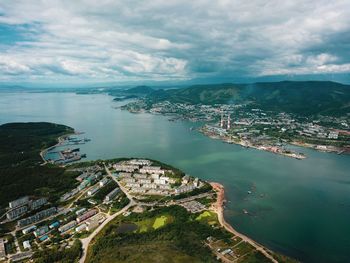 High angle view of townscape by sea against sky