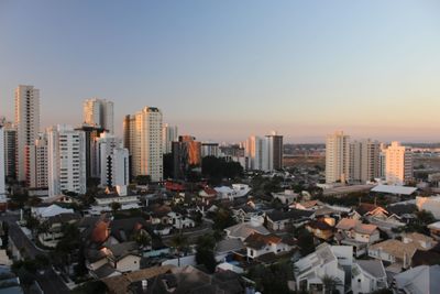 Aerial view of buildings in city against clear sky