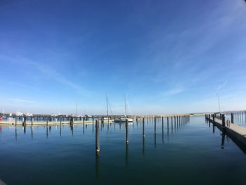 View of jetty in sea against blue sky