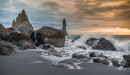 Panoramic shot of rocks on beach against sky