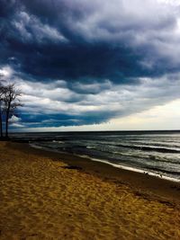 Scenic view of beach against cloudy sky