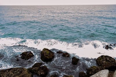 Waves crashing on rocks at shore