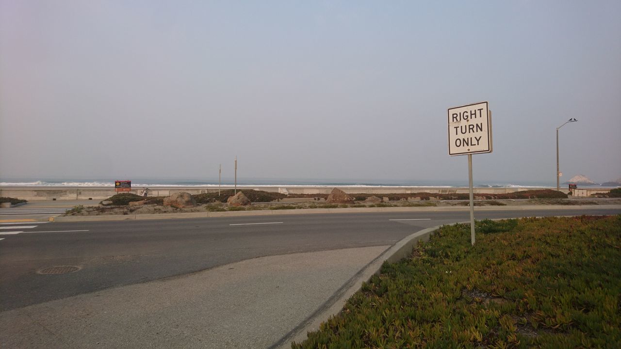 ROAD SIGN ON STREET AGAINST SKY