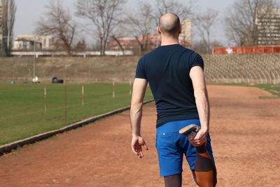 Rear view of man playing with umbrella