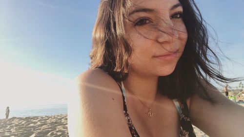 Portrait of beautiful woman on beach against sky