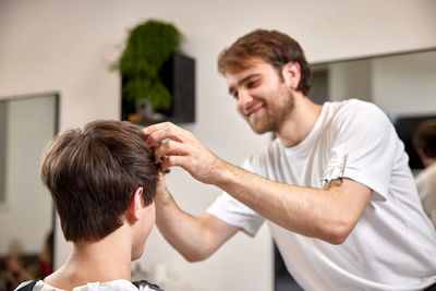 Side view of young man holding hands at home