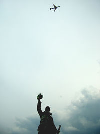 Low angle view of silhouette bird flying against sky