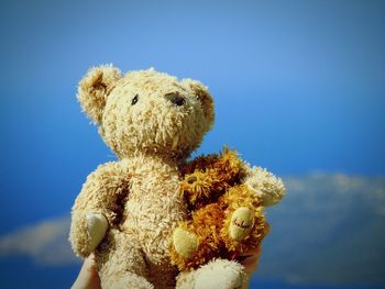 Close-up of stuffed toy against blue sky