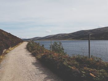 Road by sea against sky