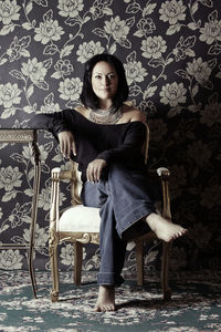 Portrait of woman sitting on chair at home