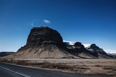 Scenic view of mountain against blue sky