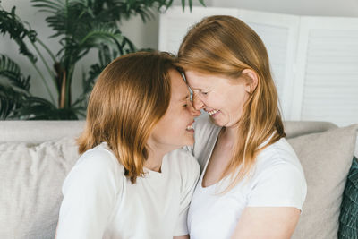 Mom and daughter with redhair. mom and daughter pressed their foreheads together and smiled.