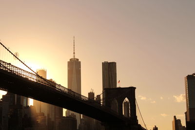 View of bridge and buildings against sky during sunset