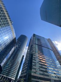 Low angle view of modern buildings against clear blue sky