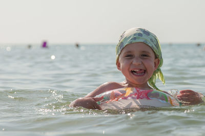 Portrait of happy boy swimming in sea