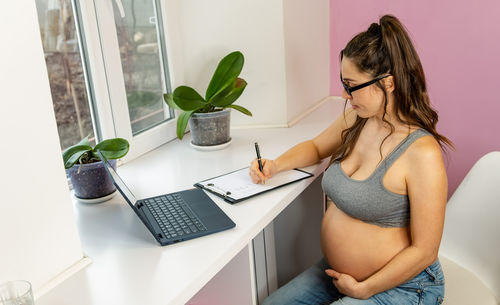 Young woman using laptop at table