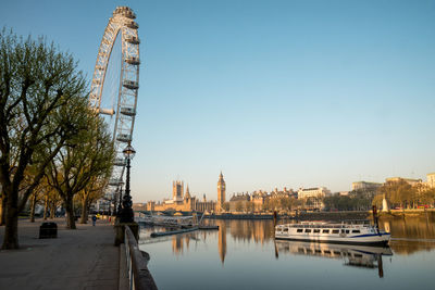 Bridge over river in city against clear sky