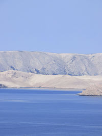 Scenic view of island pag against clear blue sky and sea
