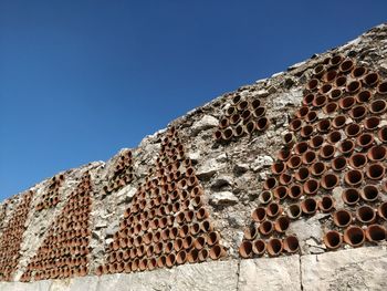 Low angle view of a patterned wall against the sky