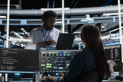 Rear view of woman using mobile phone in office