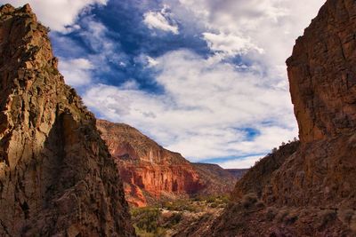 Low angle view of rocky mountains against sky