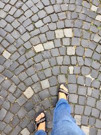 Low section of man standing on cobblestone street